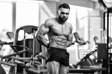 İyi eğitilmiş vücudunu gösteren genç bir adamın portresi - kaslı atletik vücut geliştirici spor sonrası vücut geliştirme modelliği pozu