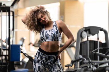 Güçlü spor salonunda duran ve kasları - esneme egzersizleri sonra poz güzel spor Fitness Model çekici genç kadın
