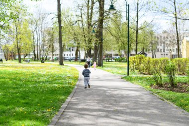 Küçük Çocuk parkta oynuyor - Güneşli bir günde koşuyor ve eğleniyor - Doğada Mutlu Anlar