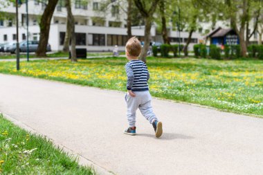 Mutlu küçük çocuk parkta eğleniyor ve koşuyor - aktif çocuk yazın açık havada eğleniyor