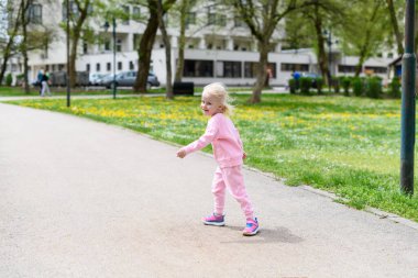 Küçük kız parkta oynuyor - Güneşli bir günde koşuyor ve eğleniyor - Doğada mutlu anlar