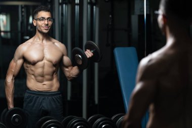 Gynecomastia Göğüs Sorunu olan Adam Spor Salonunda Bisiklet Çalışıyor - Dambıllar Konsantrasyon Kıvrımları