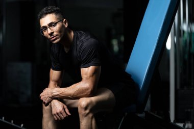 Yakışıklı ve çekici, spor salonunda rahatlayan kaslı vücudu olan Afrikalı genç bir adam.