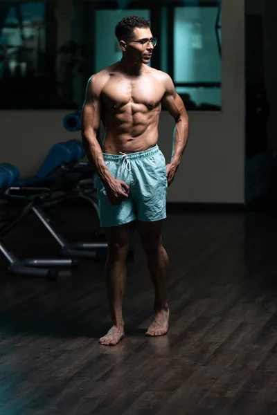 体育館とフレキシングな筋肉の強い立っている問題を胸婦人科の若い男 — ストック写真