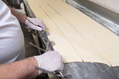 Fırına gitmeden önce fırında kruvasan yapan genç pasta şefi.