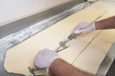 Fırına gitmeden önce fırında kruvasan yapan genç pasta şefi.