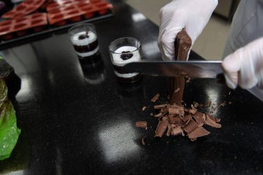 Çikolata Şefi Çikolata İçeceğini Hazırlamak İçin Küçük Kakao Çubuklarını Bıçakla Kesiyor