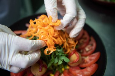 Kadın Aşçının Elleri 'nin Yakın Çekimi Et ve Dekorasyon Yemekleri ile Salata Yapıyor