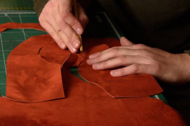Shoemaker 'ın elleri zanaat bıçağı tutuyor atölyesinde el yapımı ayakkabılar için süet deri kesiyor. Yakın çekim.
