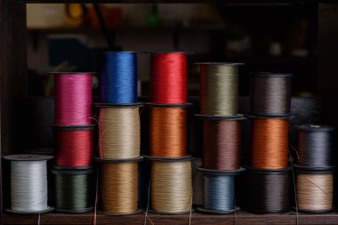 Ayakkabı yapımı için renkli iplik makaraları. Ayakkabı dikme atölyesinde dikiş ipliği.