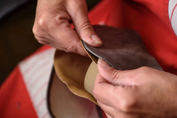 Shoemaker hands sewing the lining to the handmade leather shoe in workshop. Manufacturing of craft shoes. Small business concept