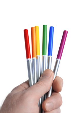 Beyaz arka planda izole edilmiş, LGBT gökkuşağı renklerinde altı parlak renkli kalem tutan bir erkek. Renkli yaşam konsepti. Yakın çekim.