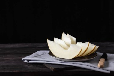 Ahşap tahtalarda bıçakla kavun parçaları. Kırsal biçim.