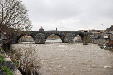 Kars Nehri ve Kars Şatosu üzerindeki antik taş köprü - Türkiye 'nin Kars kentinin başlıca turistik merkezleri. Kalenin yanında Atatürk 'ün portresi var ve Türkçe 