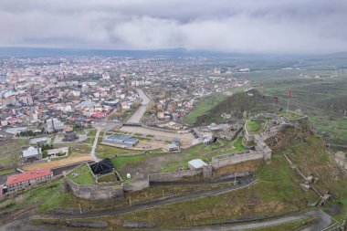 Kars Nehri ve Kars Şatosu üzerindeki antik taş köprü - Türkiye 'nin Kars kentinin başlıca turistik merkezleri. Kalenin yanında Atatürk 'ün portresi var ve Türkçe 