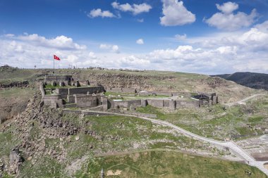Kars Nehri ve Kars Şatosu üzerindeki antik taş köprü - Türkiye 'nin Kars kentinin başlıca turistik merkezleri. Kalenin yanında Atatürk 'ün portresi var ve Türkçe 