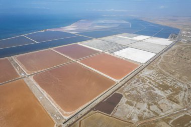 Doğal deniz tuzu göletlerinin hava aracı görüntüsü. Çiftlik arazisi. Geleneksel endüstride malzeme. Kamyona işgücü yüklemesi için tuz.
