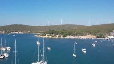 Mavi gökyüzünde beyaz bulutlar olan yeşil bir çayır üzerindeki güzel bir yel değirmeninin havadan çekilmiş fotoğrafı..