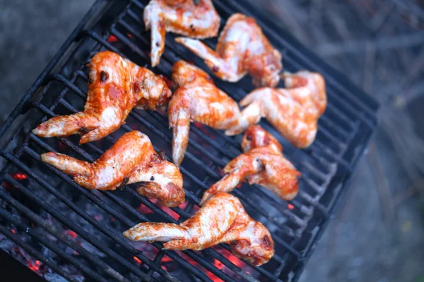 Asas de frango sendo cozidas em um churrasco ao ar livre — Fotografia de Stock