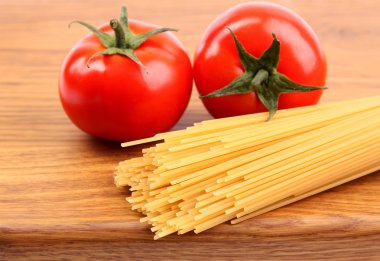 tomatoesl ve pişmemiş makarna kesme tahtası