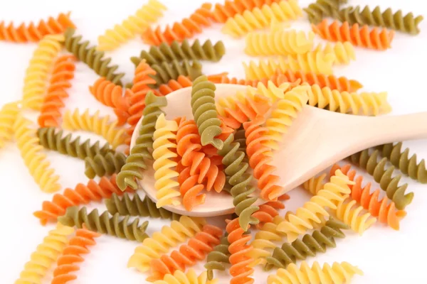 A pasta eliche tricolori and a wood spoon. — Stockfoto