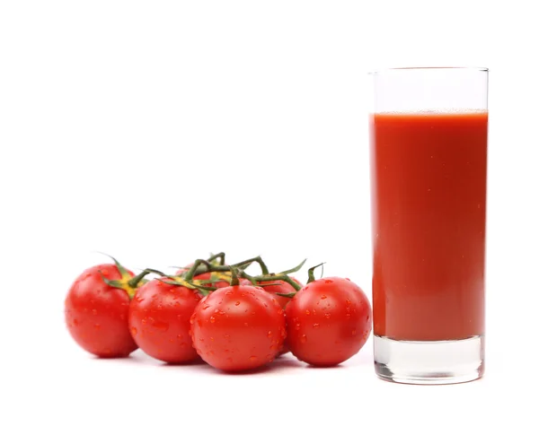 Cluster di pomodori e un bicchiere di succo di frutta — Foto Stock