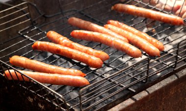 A few sausages on grill closed-up. clipart