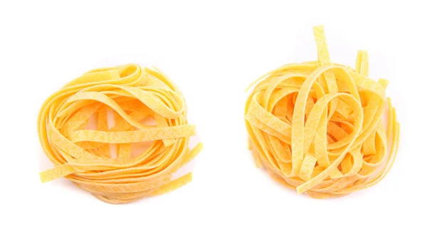 Dois ninhos de macarrão fettuccini isolados em branco . — Fotografia de Stock