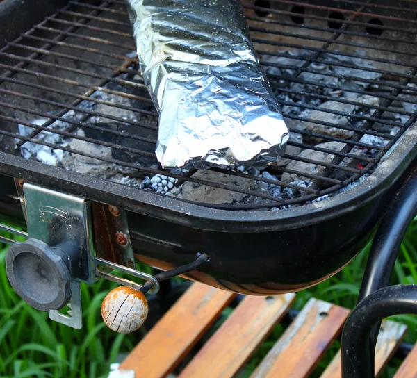 Cuisson du poisson en papier d'aluminium sur barbecue — Photo