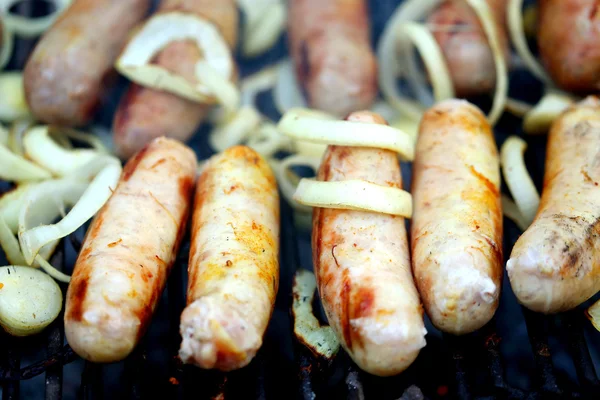 Churrasco um monte de salsichas com cebola — Fotografia de Stock