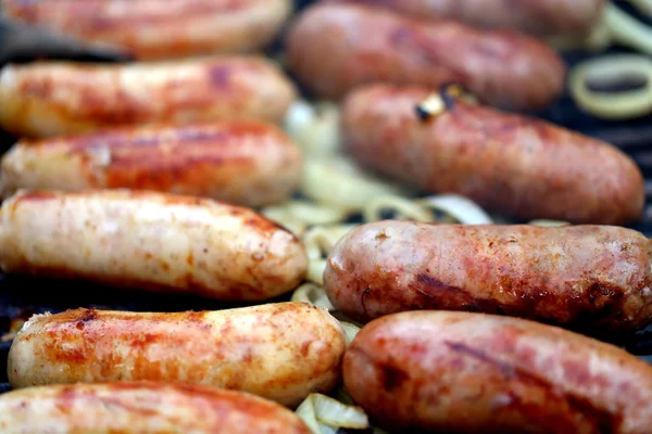 BBQ a lot of sausages with onion — Stock Photo, Image