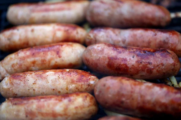 Sausages on grill with onions. — Stock Photo, Image