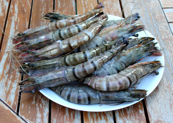 Camarones frescos en un plato en la mesa del jardín . — Foto de Stock