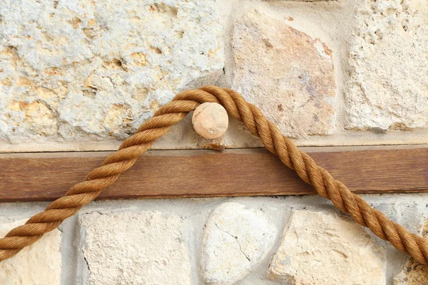 Corda no fundo de uma antiga parede de pedra — Fotografia de Stock
