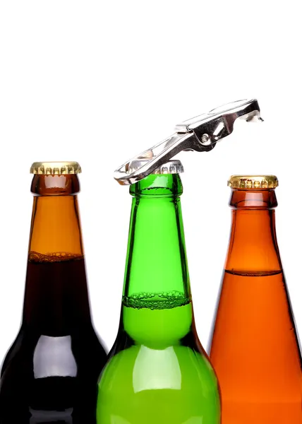 Threee bottles of beer and a opener — Stock Photo, Image