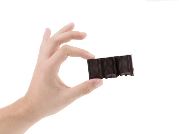 Hand hält leckeren Bissen dunkler Schokolade. — Stockfoto