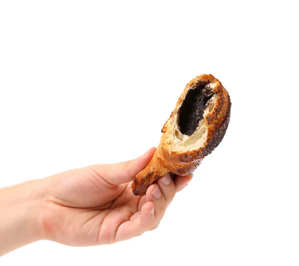 Hand holds bitten appetizing croissant with poppy. — Stock Photo, Image