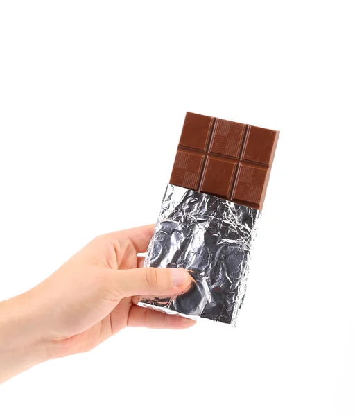 Hand holds dark chocolate bar in foil. — Stock Photo, Image