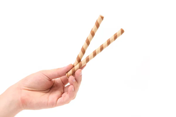 Hand holds striped chocolate wafer rolls — Stock Photo, Image