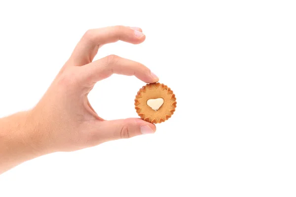 Hand holds sweet pastry with white cream heart. — Stock Photo, Image