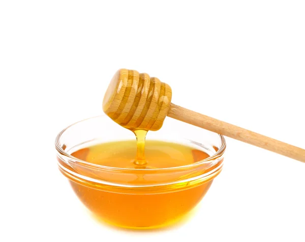 Honey dripping from a wooden dipper — Stock Photo, Image