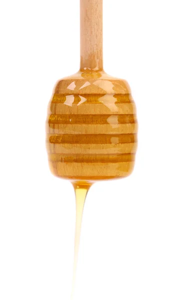 Honey dripping from a wooden dipper — Stock Photo, Image