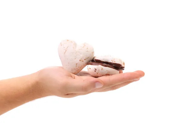 Hand holds heart shape chocolate meringues. — Stock Photo, Image