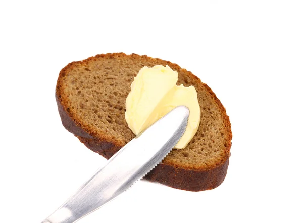 Buttering knife on brown bread. — Stock Photo, Image