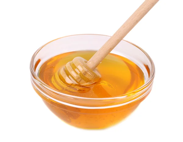 Glass bowl of honey with wooden drizzler — Stock Photo, Image