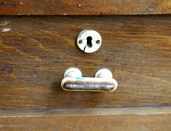 Punho de metal e buraco de fechadura de uma velha mesa de madeira . — Fotografia de Stock