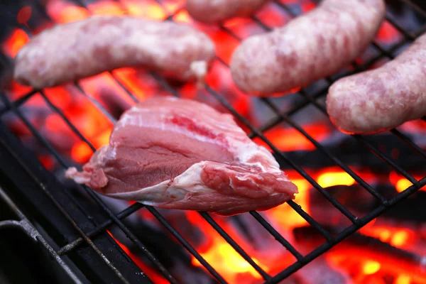 Raw meat and sausages on BBQ. — Stock Photo, Image