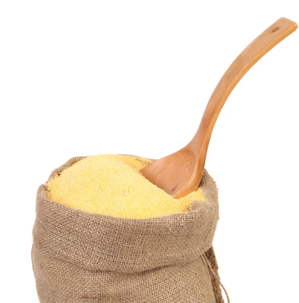 Saco de milho moído e uma colher de madeira — Fotografia de Stock