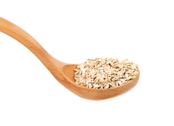 Oatmeal flakes into wooden spoon. — Stock Photo, Image