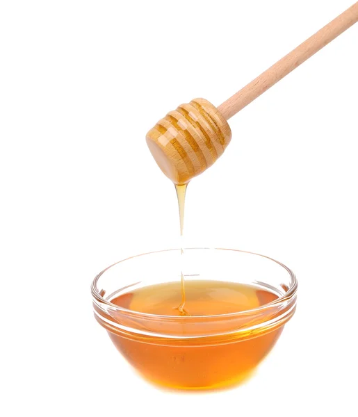 Honey dripping from a wooden dipper. — Stock Photo, Image